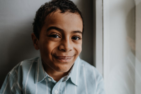 Portrait of multiracial boy sitting near the window.の写真素材