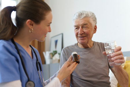 Nurse giving pills senior man in his home.の写真素材
