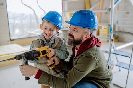 Father and his little son working on their unfinished house.の写真素材
