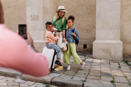 Multiracial family travelling together with small kids. Taking photo in old city cetre.の写真素材