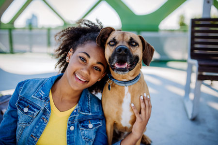 Portrait of happy multiracial girl with her dog. Concept of relationship between dog and teenager, everyday life with pet.の写真素材