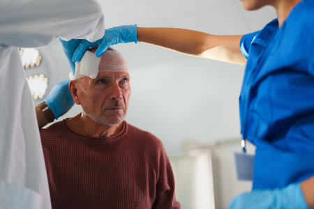 Close-up of doctor and nurse treating injury of senior man.の写真素材