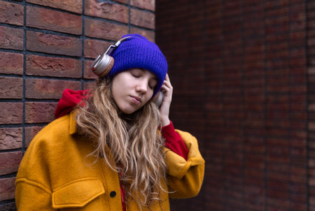 Young woman listening music outdoor, in a city.の写真素材