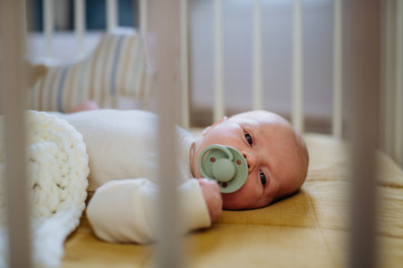 Side view of sleeping baby in little bed.の写真素材