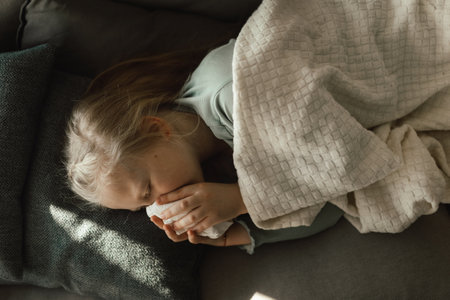 Sick little girl lying in a bed.の写真素材
