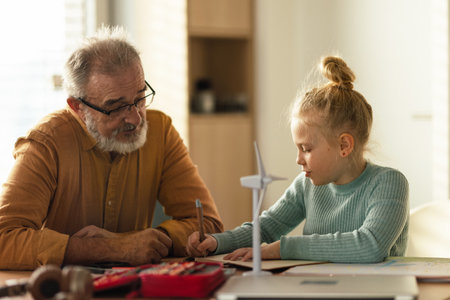 Senior man doing homework with his granddaughter.の写真素材
