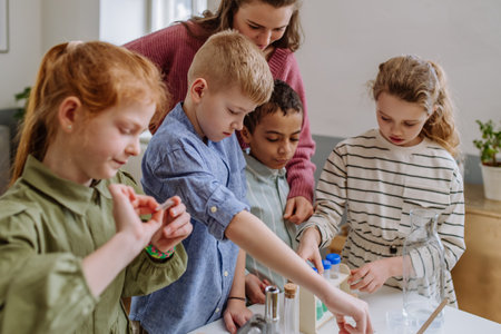 Young teacher doing chemistry experiment with pupils during science education.の写真素材