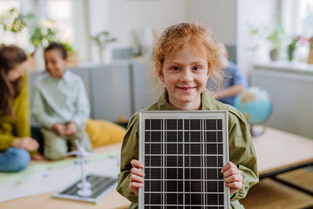 Little girl posing with solar panel during a school lesson.の写真素材