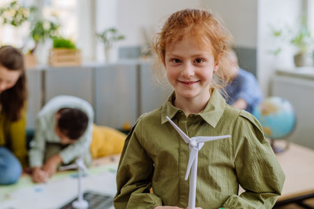 Little girl posing with model of winter turbine during a school lesson.の写真素材