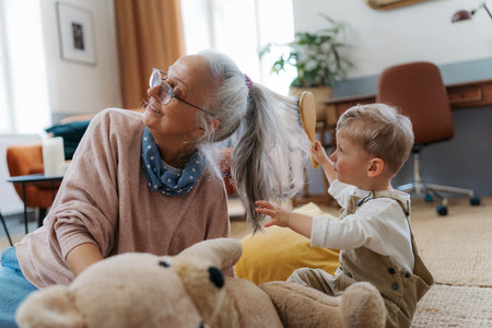 Little boy combing his grandomther with hairbrush.の写真素材