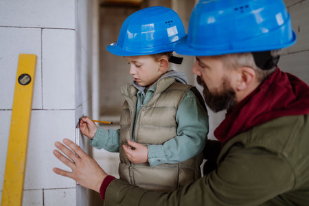 Father and his little son working on their unfinished house.の写真素材