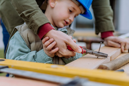 Close- up of father and his little son working outdoor with wood.の写真素材