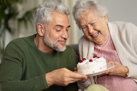 Mature man visiting his senior mother at her apartment.の写真素材