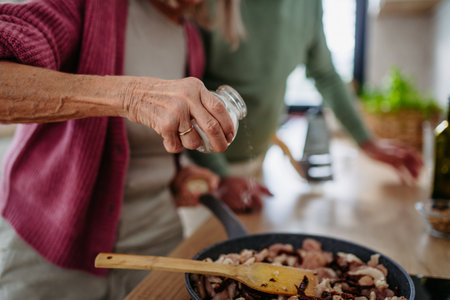 Senior couple cooking together in their kitchen.の写真素材