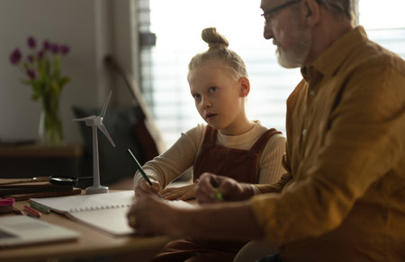 Senior man doing homework with his granddaughter.の写真素材