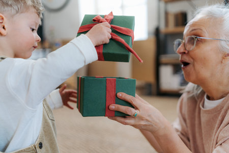Grandmother giving gift to her little grandson.の写真素材