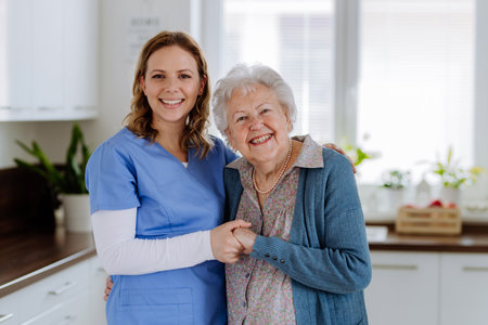 Young nurse hugging her senior woman client.の写真素材