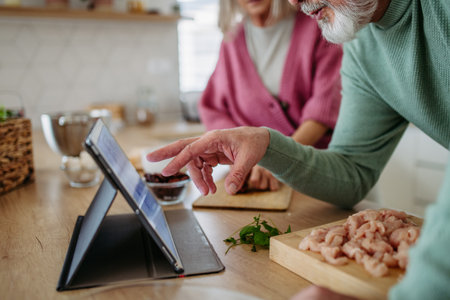 Senior couple cooking together in their kitchen.の写真素材
