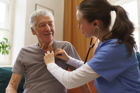 Young nurse checking elderly senior in his home.の写真素材