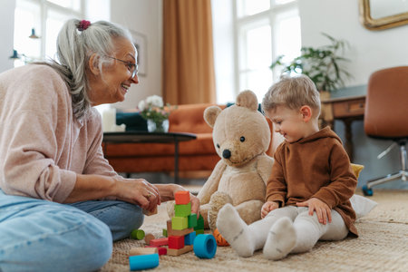 Grandmother playing with her little grandson, building a block set.の写真素材