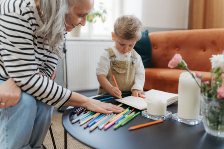 Grandson drawing in a notepad with his grandmother.の写真素材