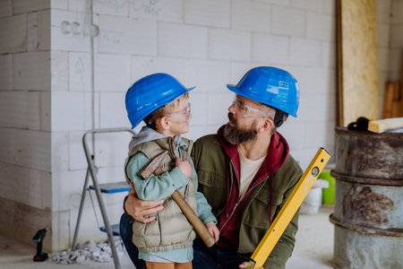 Father and his little son working on their unfinished house.の写真素材