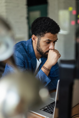 Young frustrated man sitting in front of computer in his office.の写真素材
