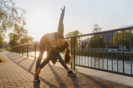 Attractive young woman stretching her arms and legs before her early morning exerciseの写真素材