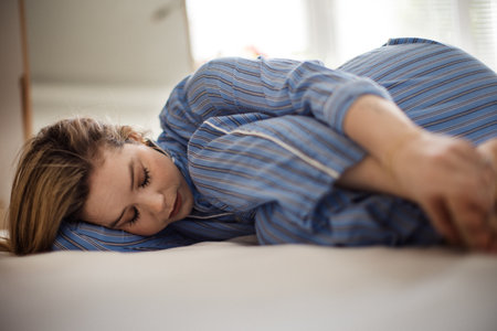 Young woman lying alone in her bed, concept of mental health.