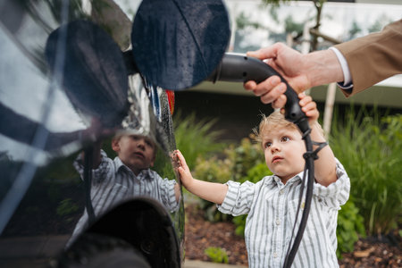 Close up of man and his little son charging their electric car.の写真素材