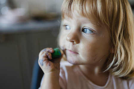 Portrait of cute little girl playing with playdough.