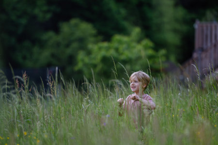 Happy boy playing and running on a meadow.の写真素材