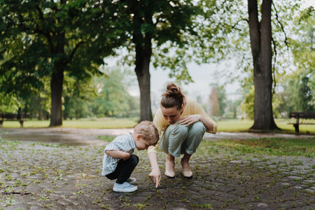Single mother with her little son spending together time in public park.の写真素材