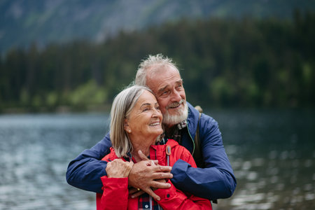 Portrait of beautiful active senior couple hiking together in autumn mountains.の写真素材