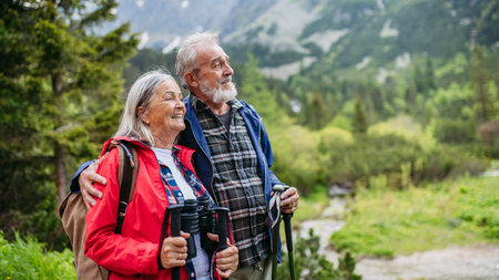 Active senior couple hiking together in autumn mountains.の写真素材