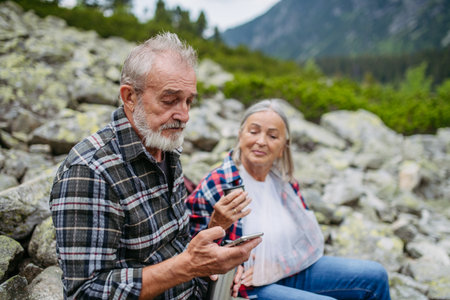 Senior woman injured her arm during hike in the mountains.