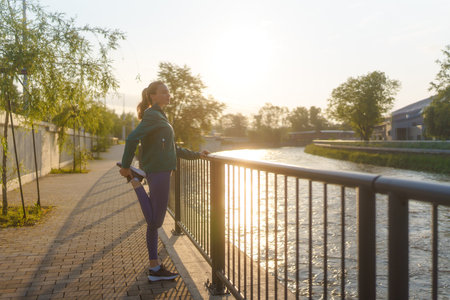 Attractive young woman stretching her legs before her early morning exerciseの写真素材