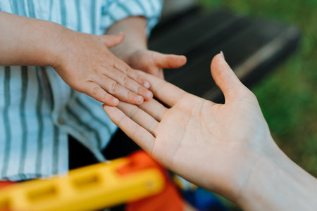 Mother and child are touching palms, expressing love.の写真素材