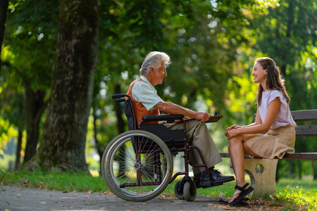 A young caregiver spending quality time with lonely senior client in the city park.の写真素材