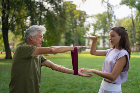 The senior man exercising in the park, using resistance band.の写真素材