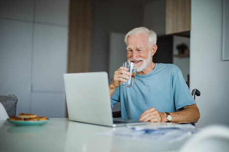 Senior man in a wheelchair working during retirement.の写真素材