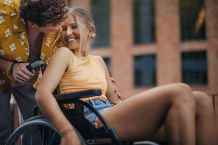 Beautiful gen Z girl in a wheelchair with her boyfriend.の写真素材