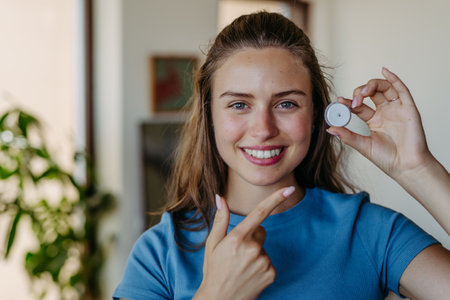 Beautiful diabetic girl pointing at continuous glucose monitor.