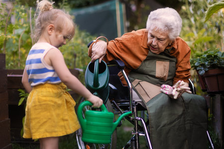 Portrait of a little adorable girl helping her grandmother in the garden.の写真素材