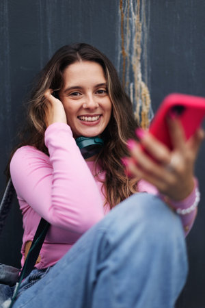 Portrait of generation z girl student sitting outdoors in the city.