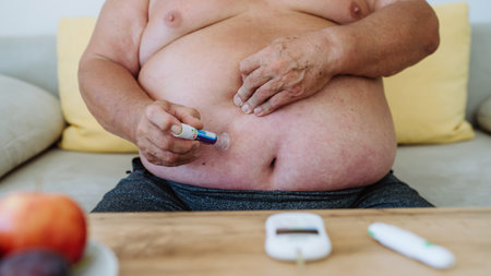Close up of diabetic man using continuous glucose monitor to check blood sugar level.の写真素材