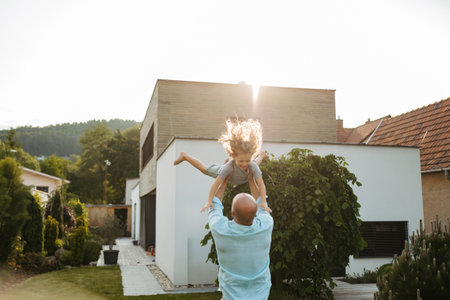 Father throwing little son up in the air.の写真素材
