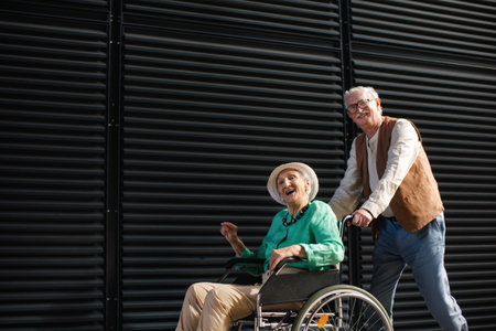 Elderly man pushing his lovely wife in wheelchair.