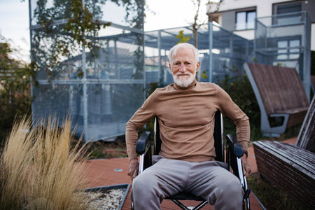 Portrait of a elegant elderly man in wheelchair in rooftop garden.の写真素材