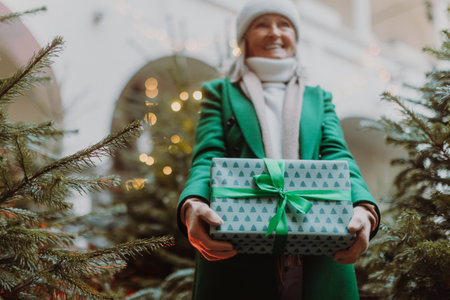 Senior woman holding a lot of Chrismtas gifts in her hands.の写真素材